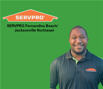 smiling African American man in SERVPRO shirt with company logo in background