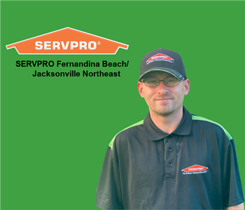 Man smiling with SERVPRO hat and shirt on