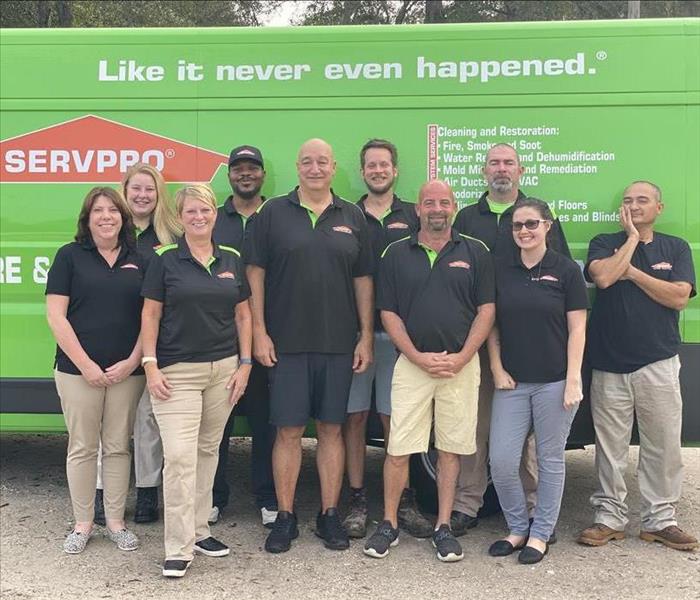 The SERVPRO of Fernandina Beach/Jacksonville team in uniforms and standing in front of a company van.