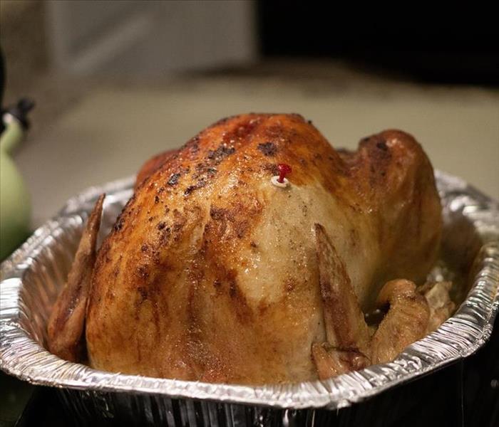 A fried turkey in an aluminum pan on a countertop.